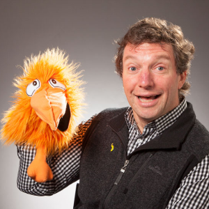 Dr. Tim Bell posing with an orange bird puppet