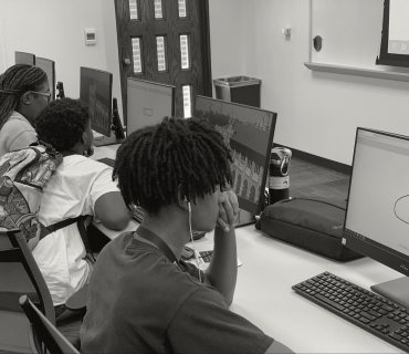 black and white image of black students in a computer science classroom.
