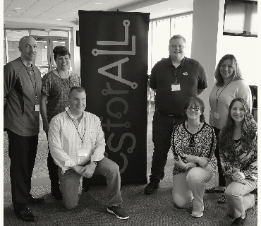 Teachers posing in front of a CSforALL banner