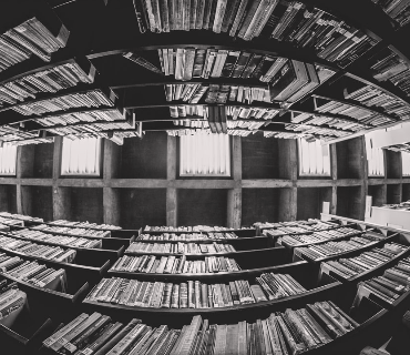 Black and white image of two bookshelves shot from below in the style of a fish eye lens