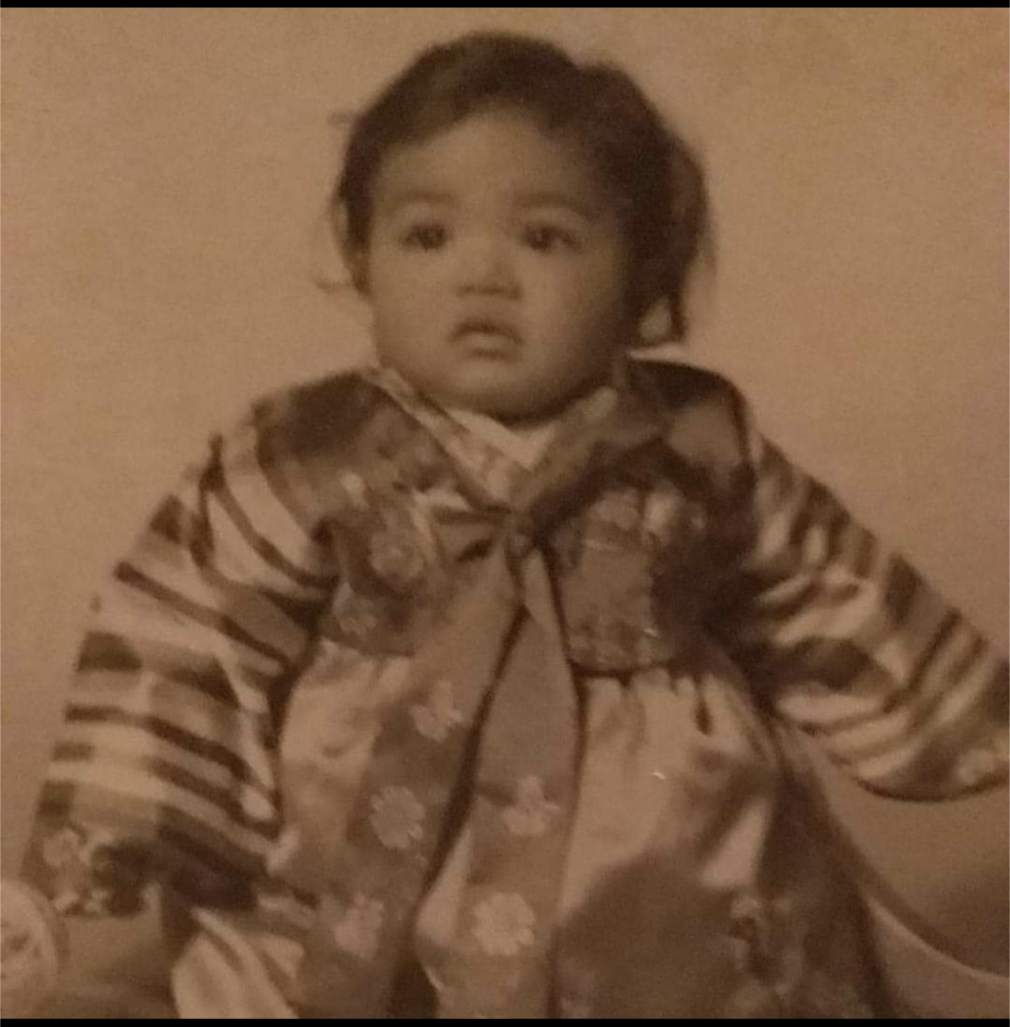 Photo of a baby with east asian features wearing a hanbok, or traditional korean dress