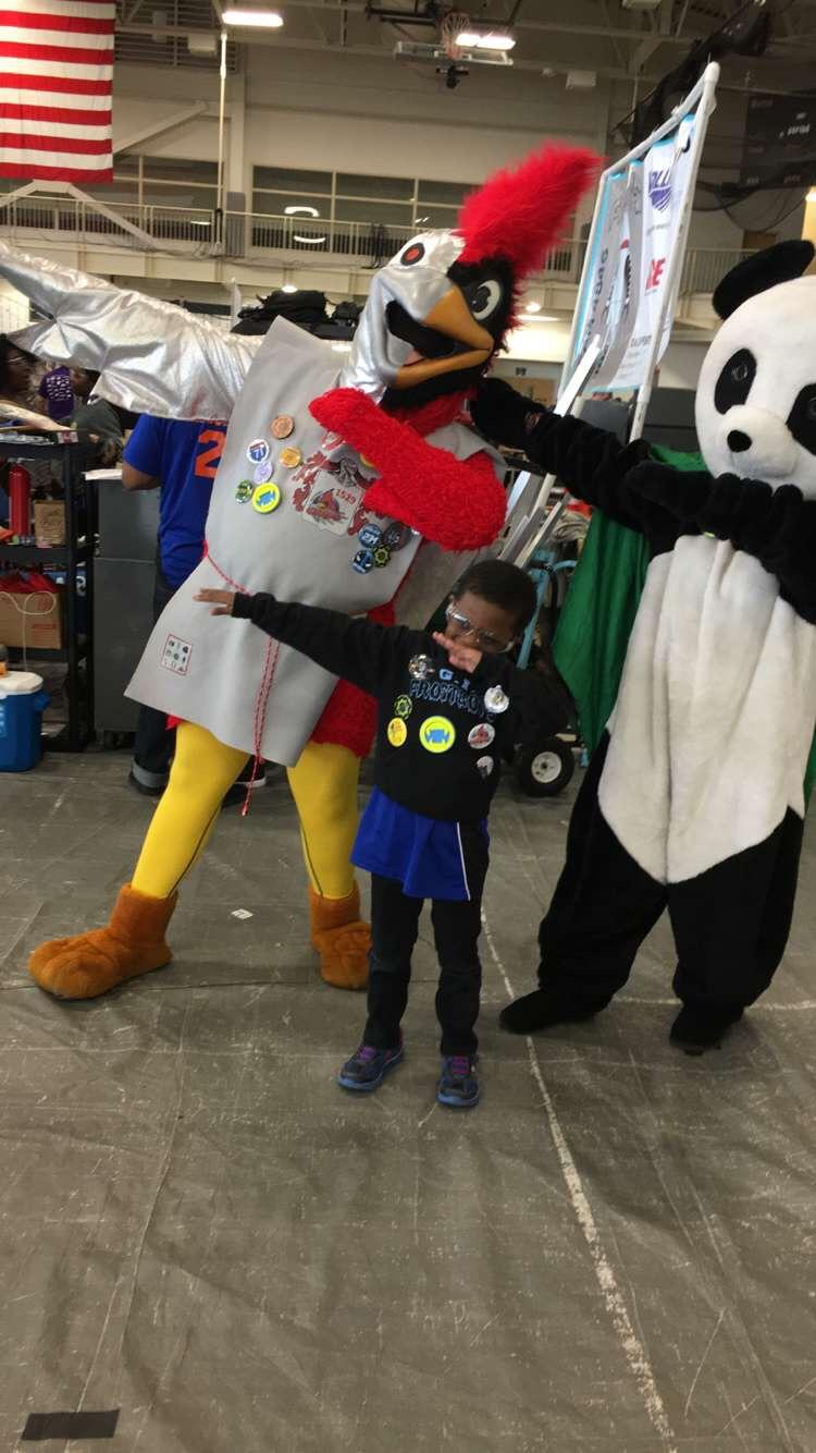 Gray-Ward's son posing with mascots at a robotics convention