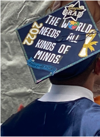 A graduate cap that reads, "The world needs all kinds of minds." A logo for autism awareness month is the "O" in World