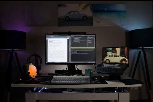 A desktop set up in a low light office, with a coding program open on the monitor