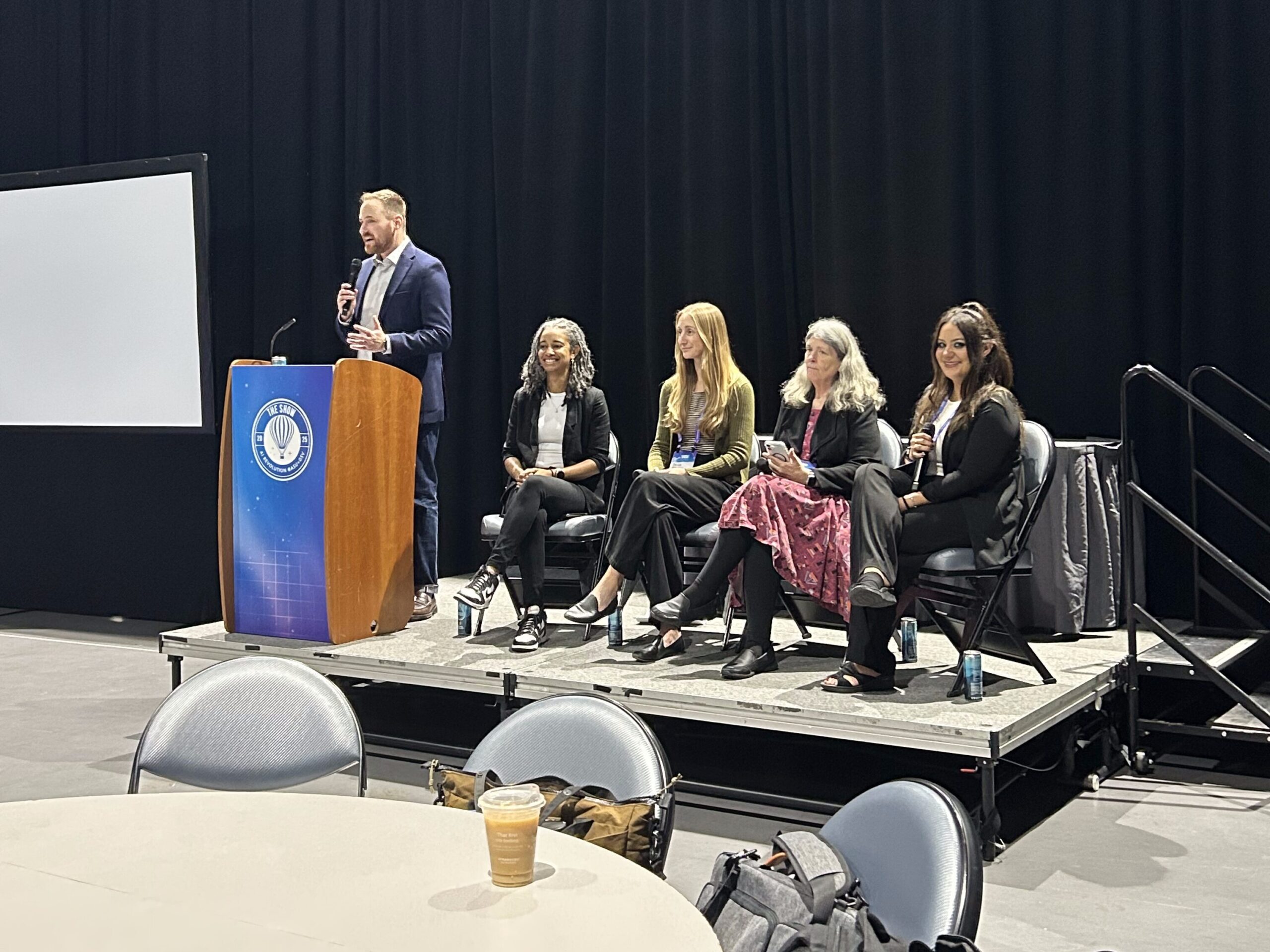 CSTA executive director Jake Baskin speaks while Michelle sits on a panel onstage