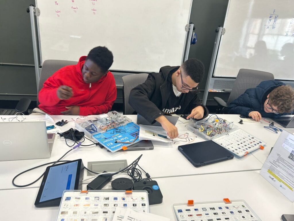Three boys working on a physical computing project
