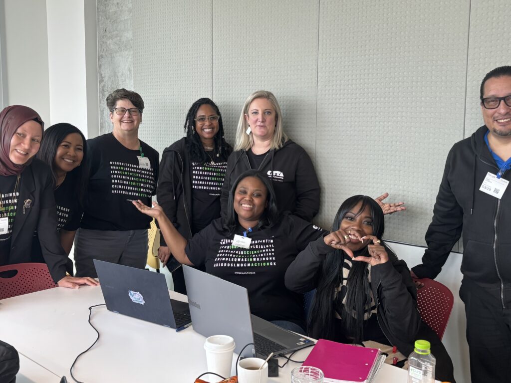 Chala making a heart with her hands while surrounded by other impact fellows