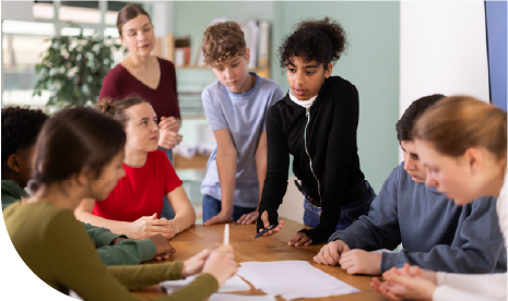 A teacher observes a small-group discussion among her middle school students, reinforcing inclusive collaboration.