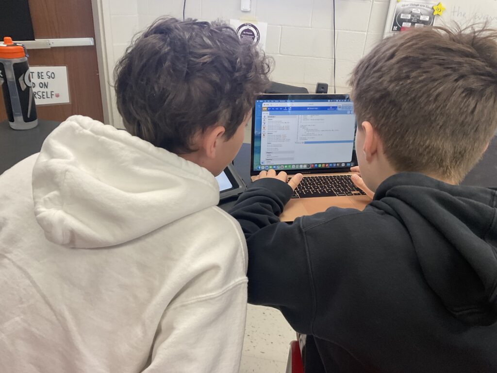 Two boys coding on a laptop