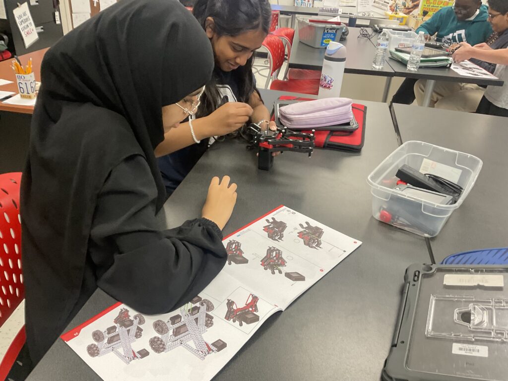 Two students reading the instructions for the physical robotics project